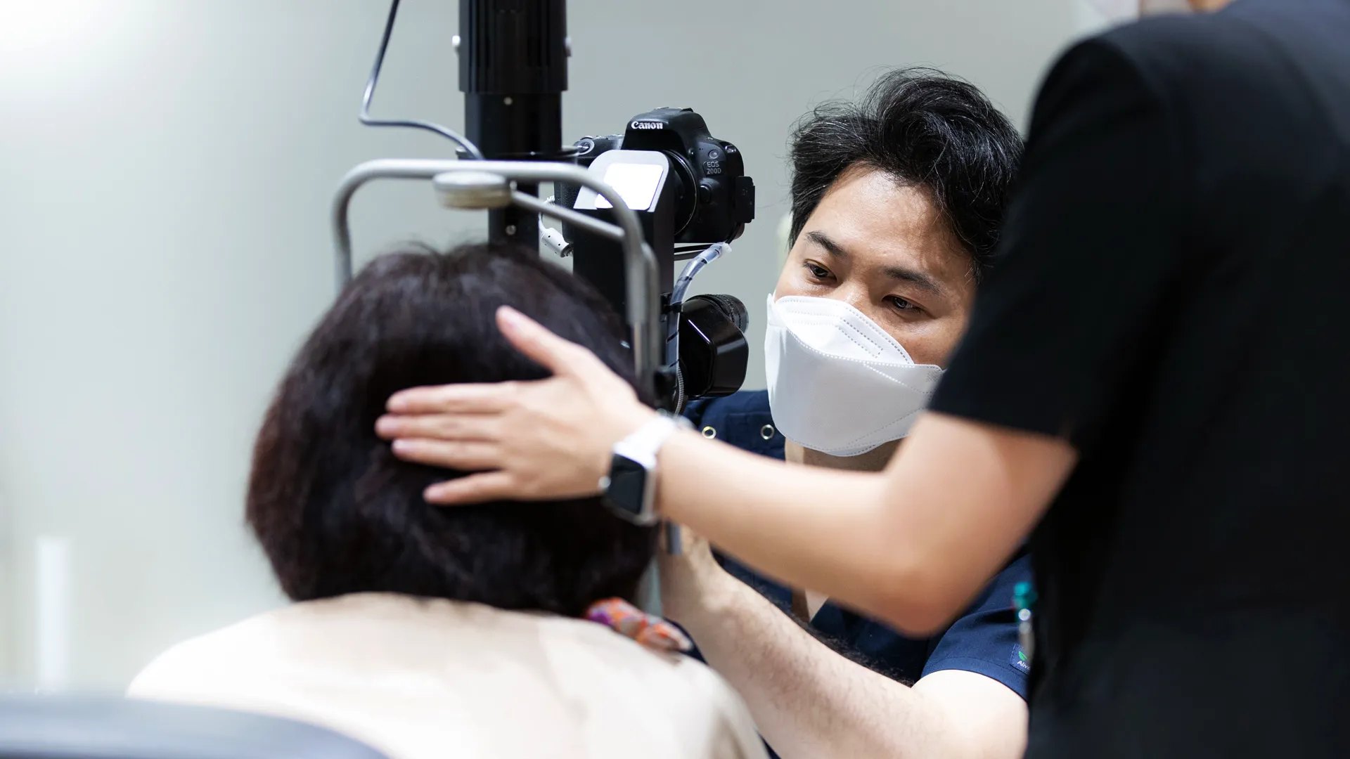 세극등 현미경 앞에서 환자의 눈을 살펴보는 의료진