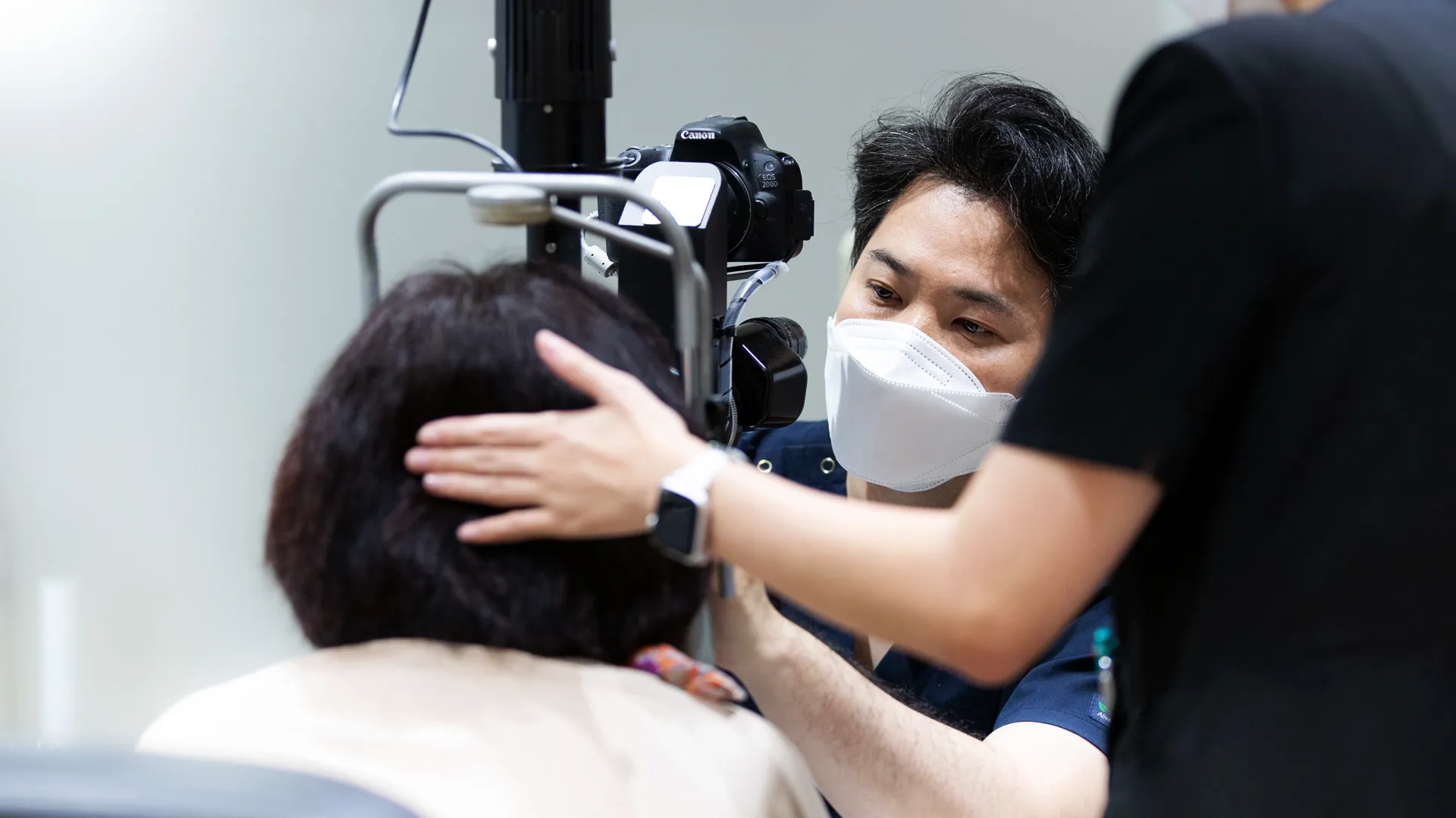 세극등 검사에서 의료진이 환자 머리를 잡아주는 장면