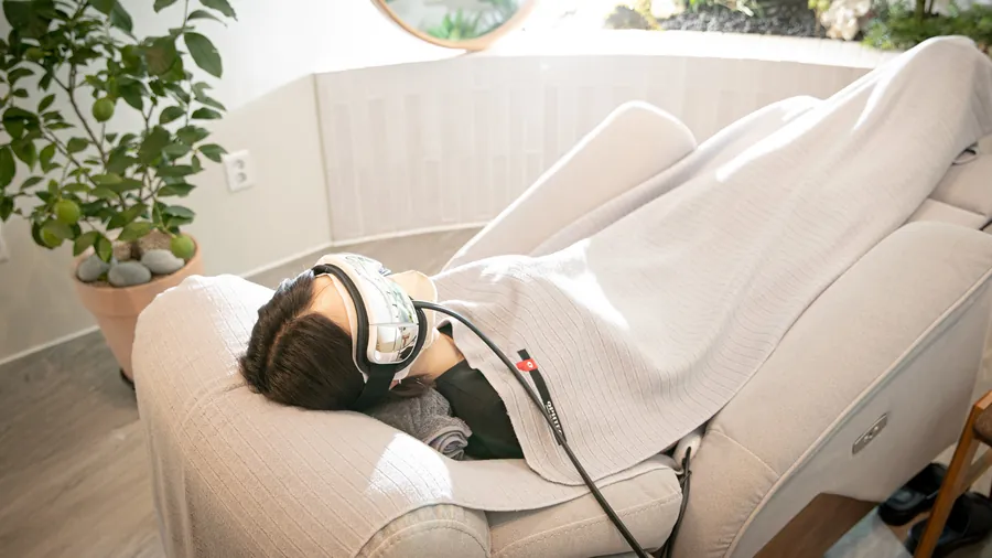 리클라이너에 누워 온열 안대를 착용한 환자