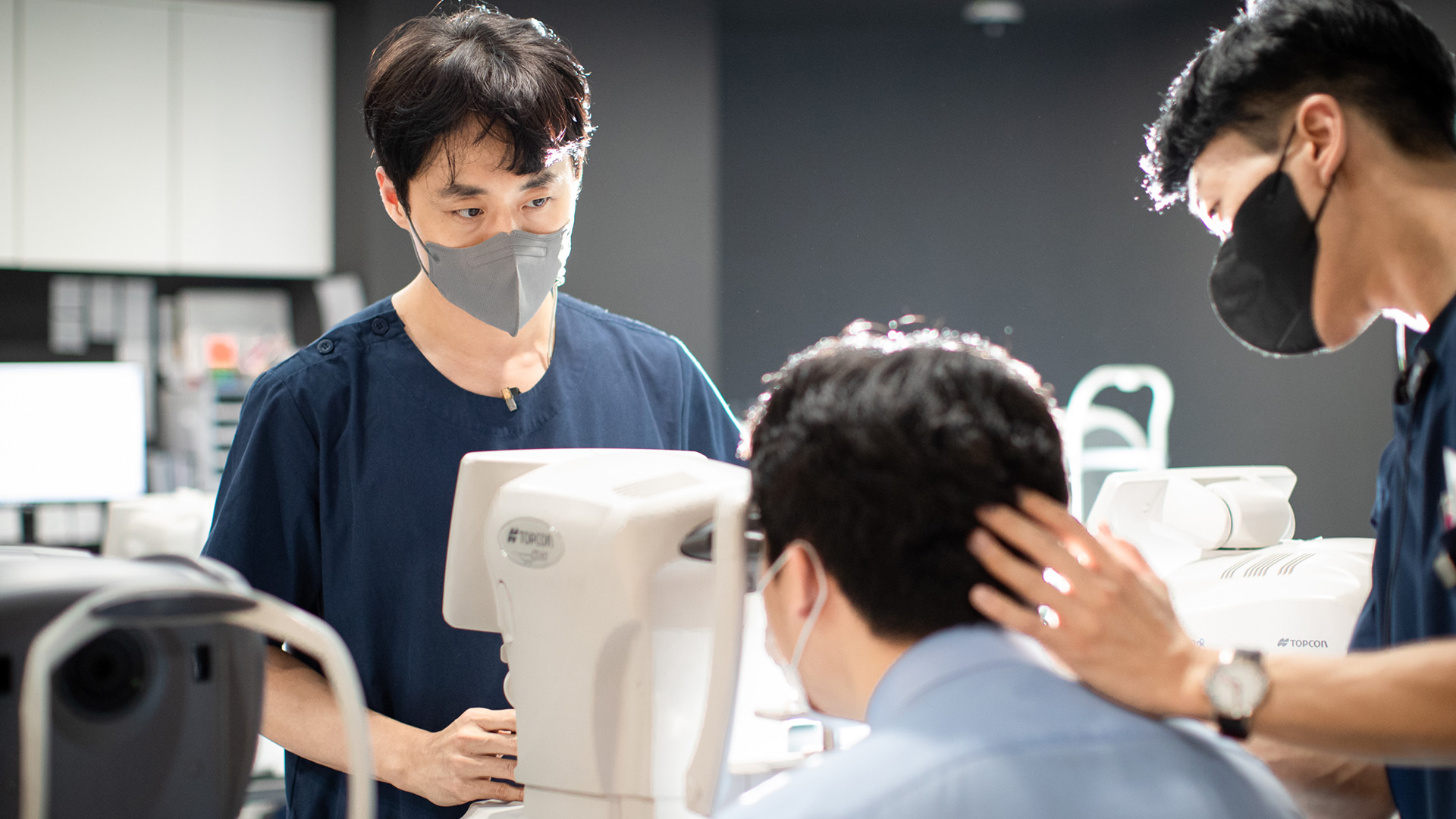 의료진이 안과 검사 장비 앞에서 검사를 진행하는 모습